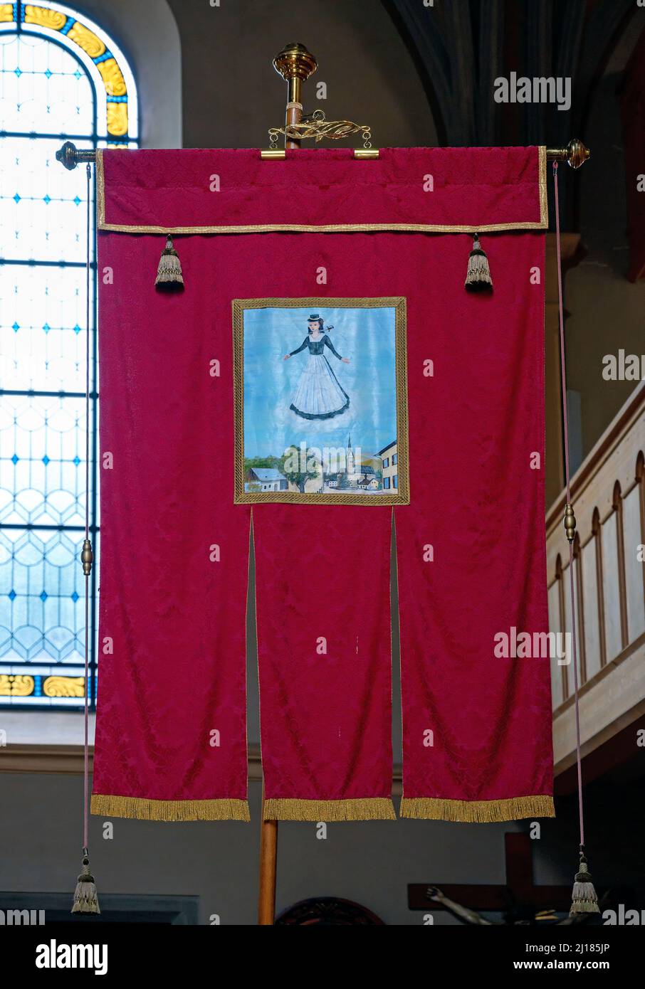 processional banner with picture of saint Lucia wearing a dirndl with sword through the throat from the parish church of Niedernsill, Austria Stock Photo