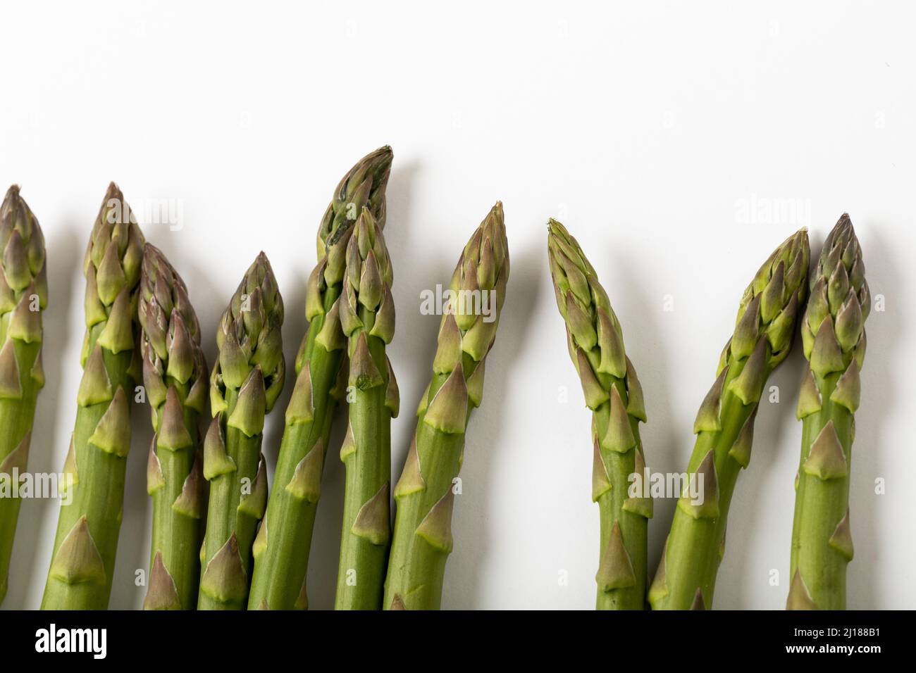 Overhead view of green raw asparagus against white background Stock Photo