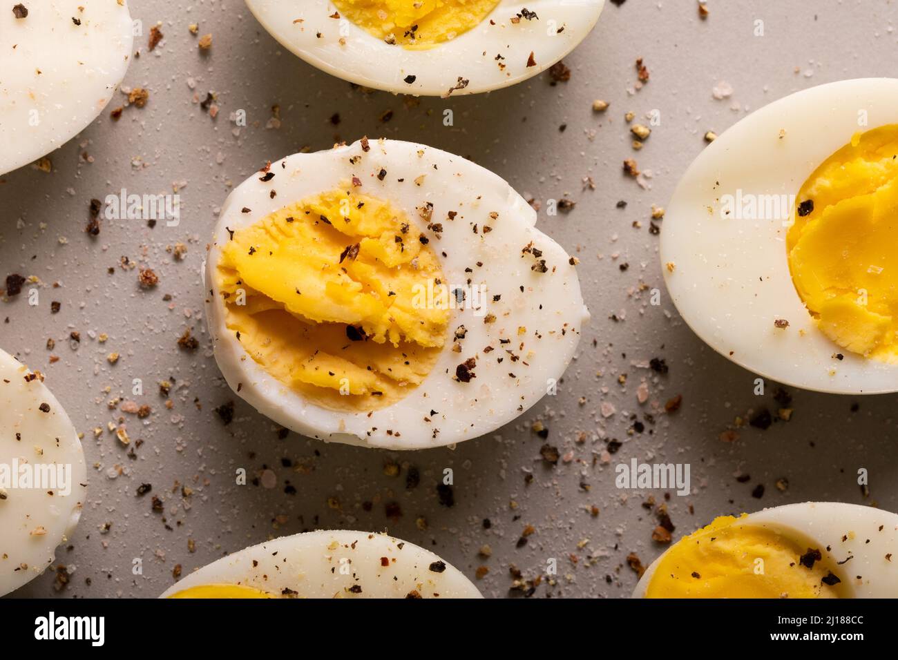 Overhead close-up view of fresh boiled white eggs with peppercorn seasoning Stock Photo