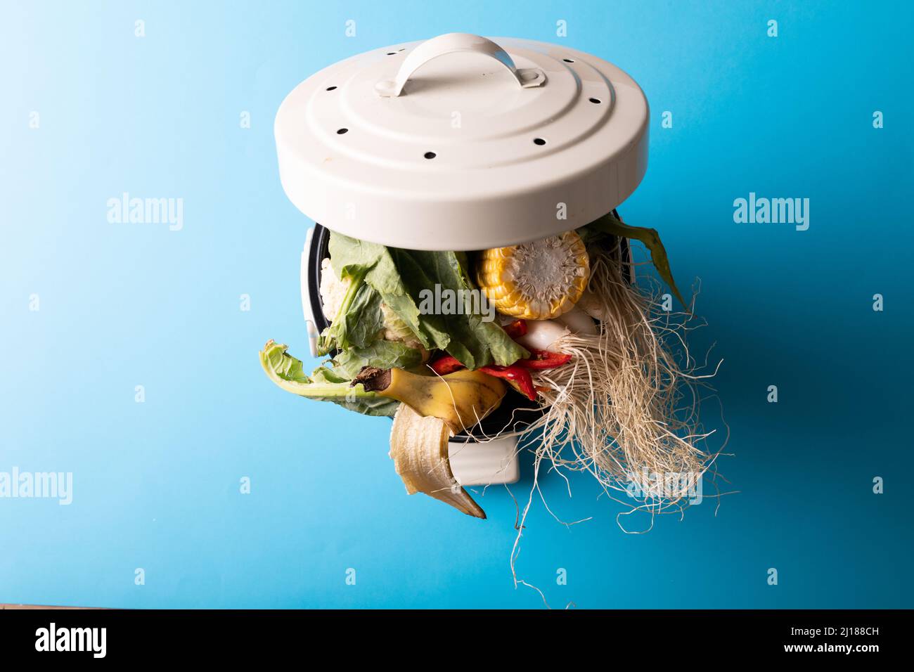 High angle view of overload organic waste in compost bin over blue background Stock Photo