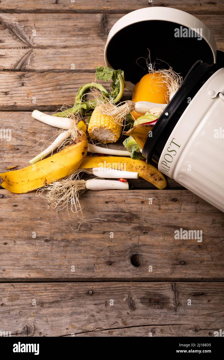 Directly above view of spilled organic waste in compost bin over wooden table Stock Photo