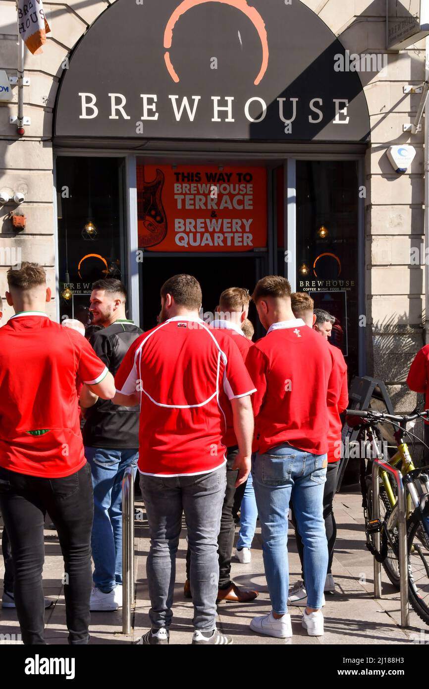 Cardiff, Wales March 2022 Welsh rugby fans queuing to get into a pub