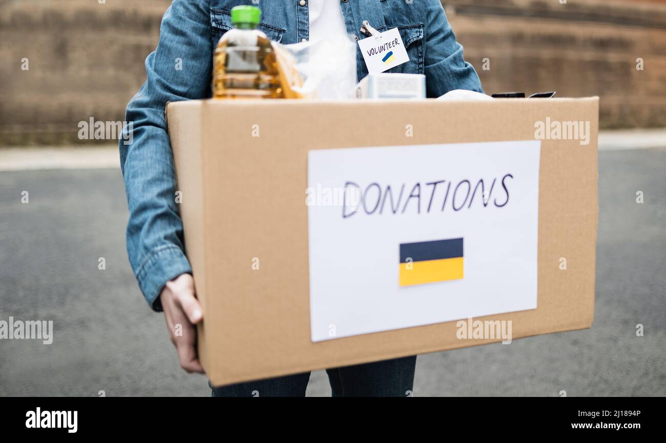 Volunteer collecting box with donations for Ukrainian refugees - Humanitarian aid for Ukraine Stock Photo