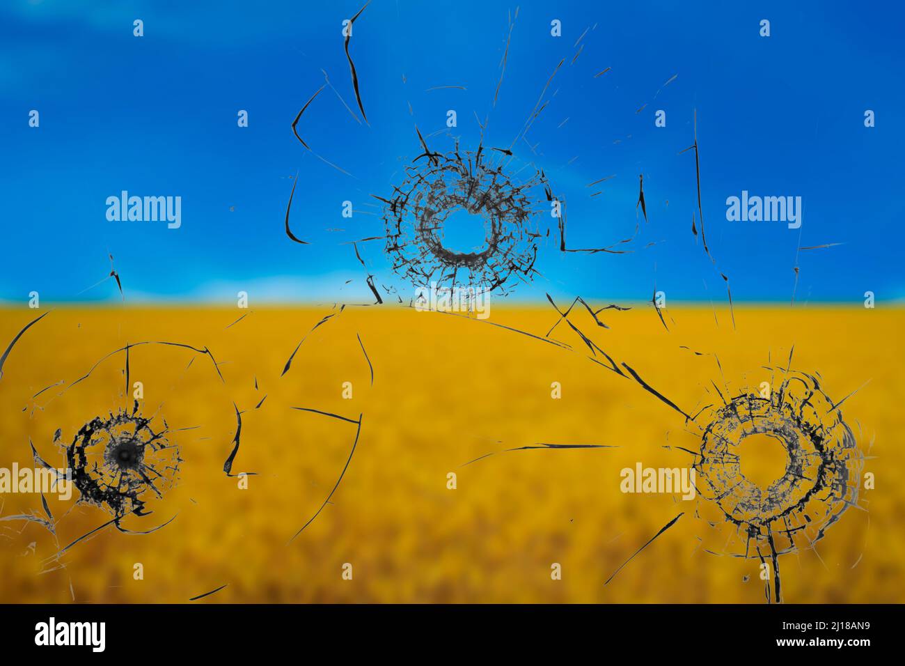 War threat concept. Hole in the glass from a bullet on the background of the flag of Ukraine Stock Photo
