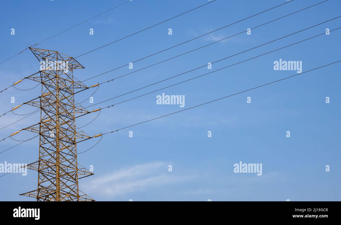 High voltage power transmission tower under the sunny blue sky with ...