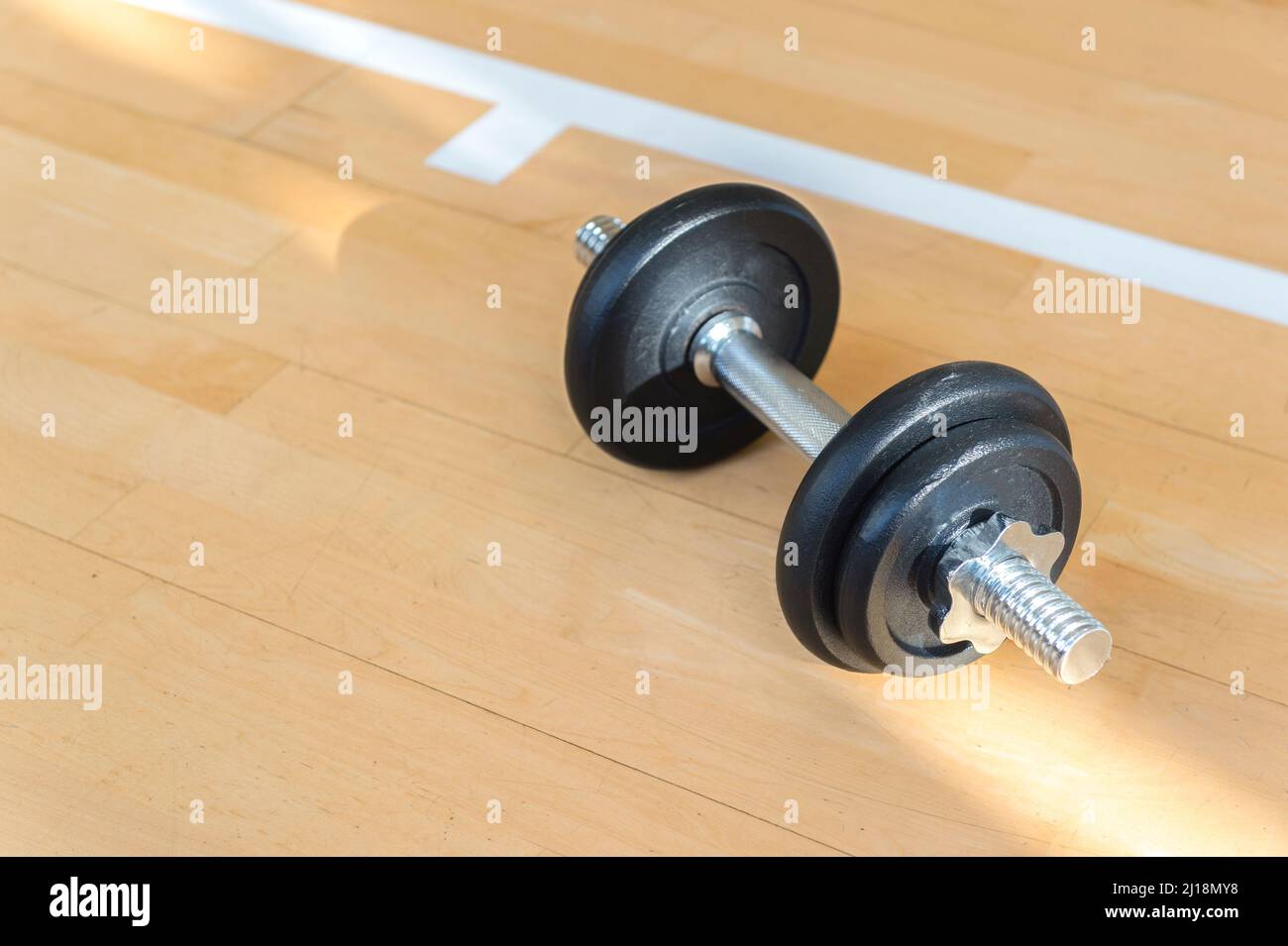 Dumbbell on wooden surface. Concept of rehabilitation and sport training equipment Stock Photo