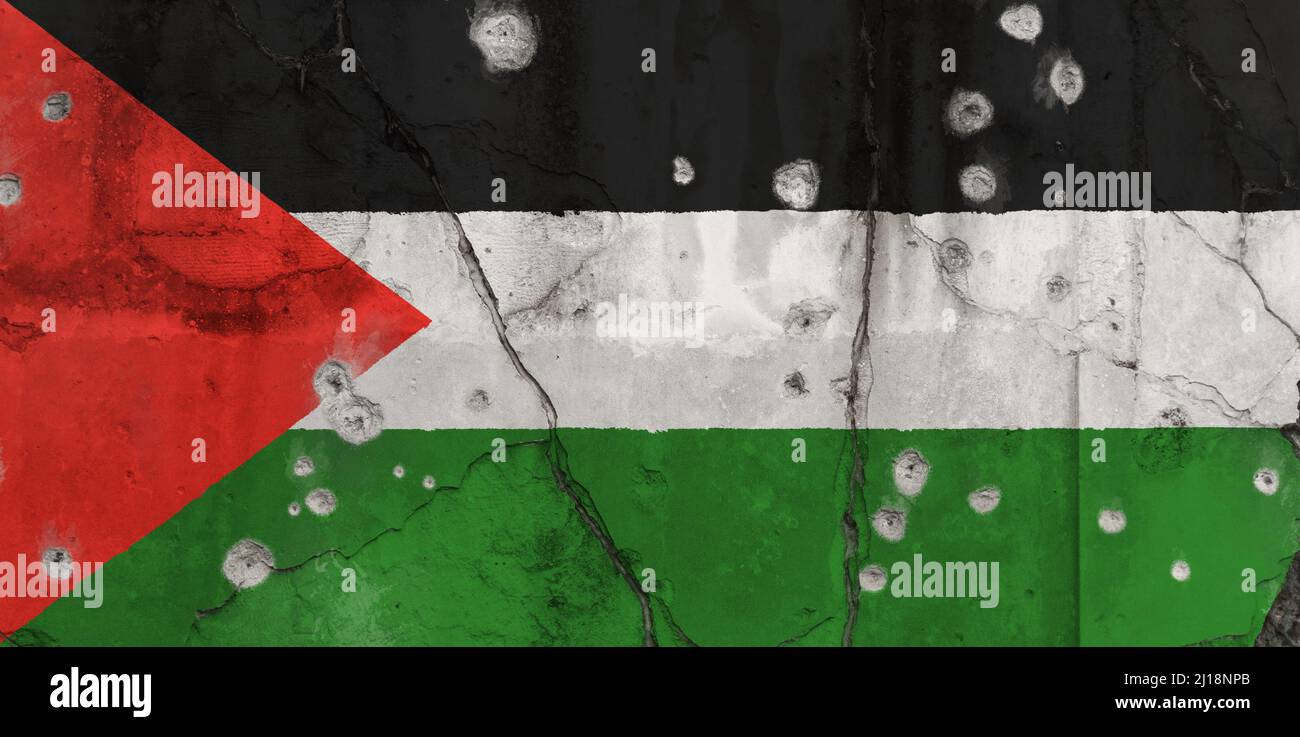 Full frame photo of a weathered flag of Palestine painted on a cracked wall with bullet holes. Violence and war in Palestine concept. Stock Photo