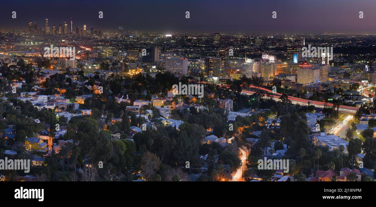 An areal view of a city with many buildings and trees at night Stock Photo