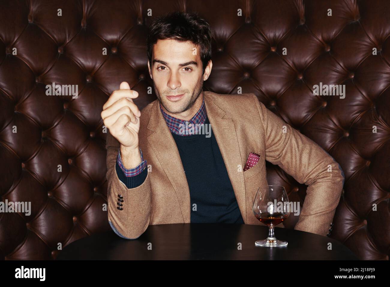 Enjoying the finer things. Portrait of a handsome young man drinking in a club. Stock Photo