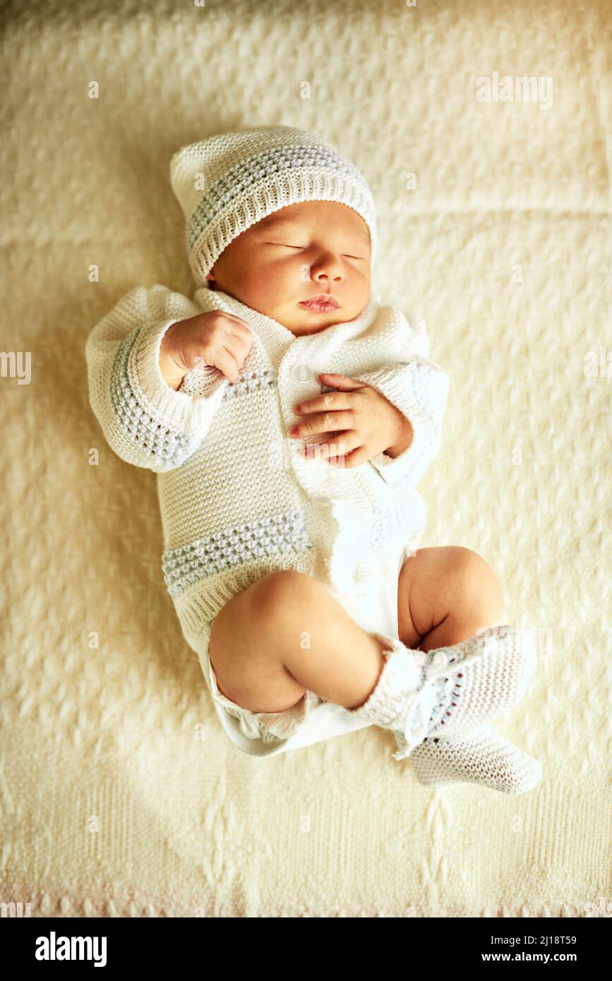 Fast asleep. Shot of a tired little baby boy sleeping with his eyes closed on a bed at home. Stock Photo