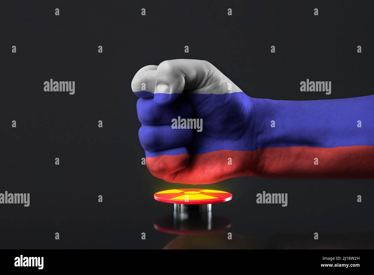The threat of nuclear war. Russia threatens the world with nuclear weapons. A fist painted in the colors of the Russian flag presses a large red Stock Photo