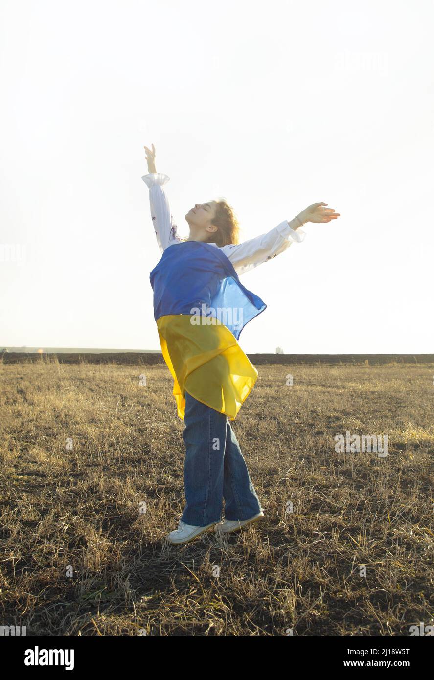 young woman with yellow and blue Ukrainian flag. a request for help to Ukraine, drawing attention to the issue of supporting Ukrainians in the world. Stock Photo