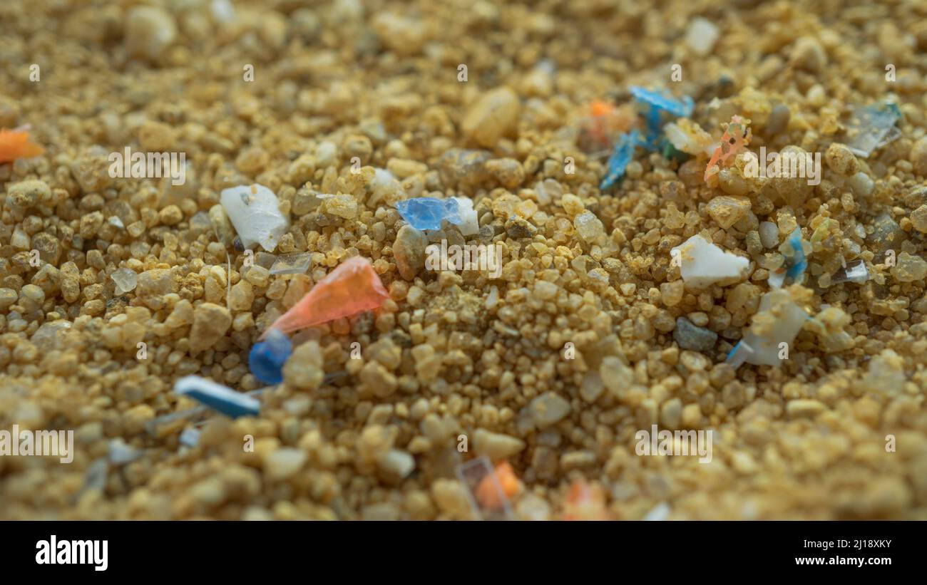 Microplastics in the sand on the beach. Concept of global warming and climate change. Non-recyclable plastic pollution in the oceans. Stock Photo
