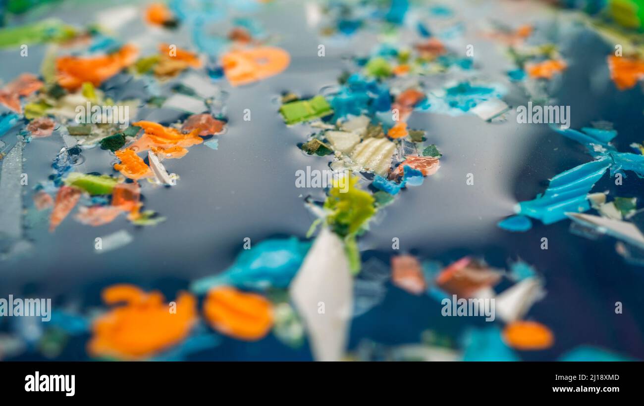 Microplastics on the surface of a polluted water. Concept of global warming and climate change. Stock Photo