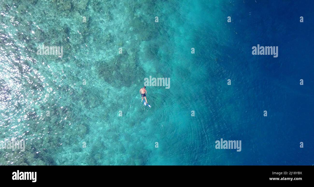 A man diving in azure waters of Rasdhoo Island, The Maldives Stock Photo