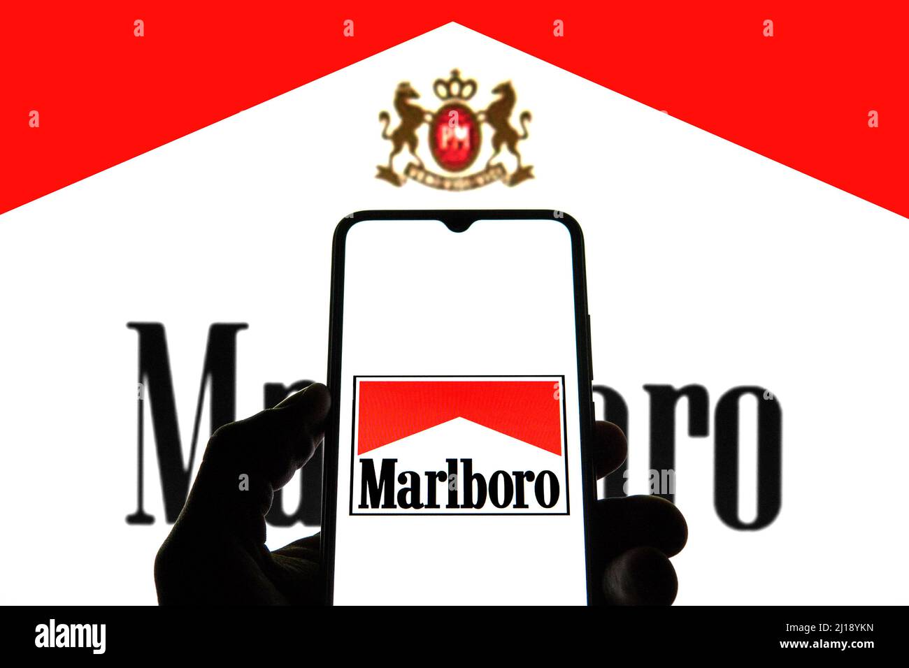 In this photo illustration a Marlboro logo seen displayed on a smartphone with a Marlboro logo in the background. Stock Photo
