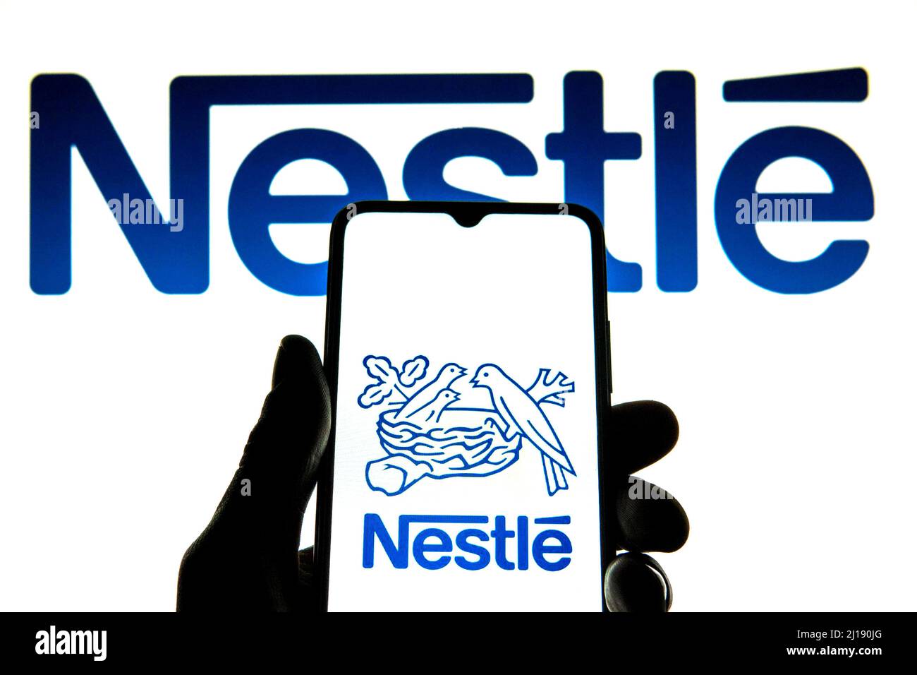 Spain. 23rd Mar, 2022. In this photo illustration a Nestle logo seen displayed on a smartphone with a Nestle logo in the background. (Credit Image: © Thiago Prudencio/SOPA Images via ZUMA Press Wire) Stock Photo
