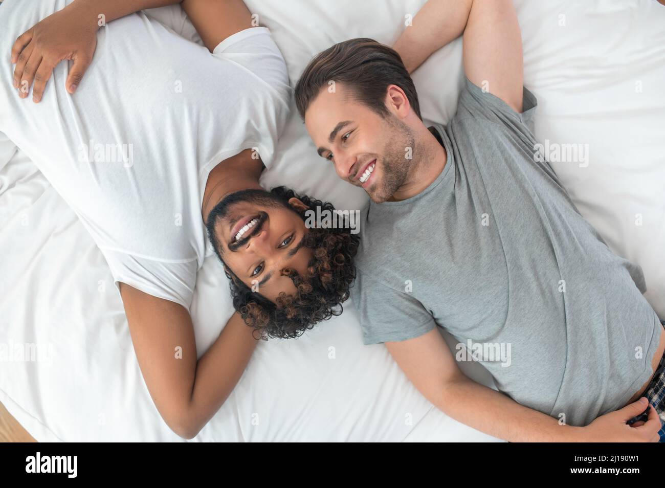 Joyful gay couple resting in their bedroom Stock Photo