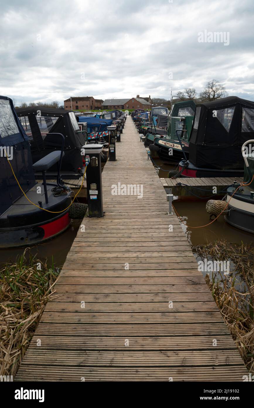 A board walk jetty at a narrow boat marina, with lighting, electric , mooring and water points. Stock Photo