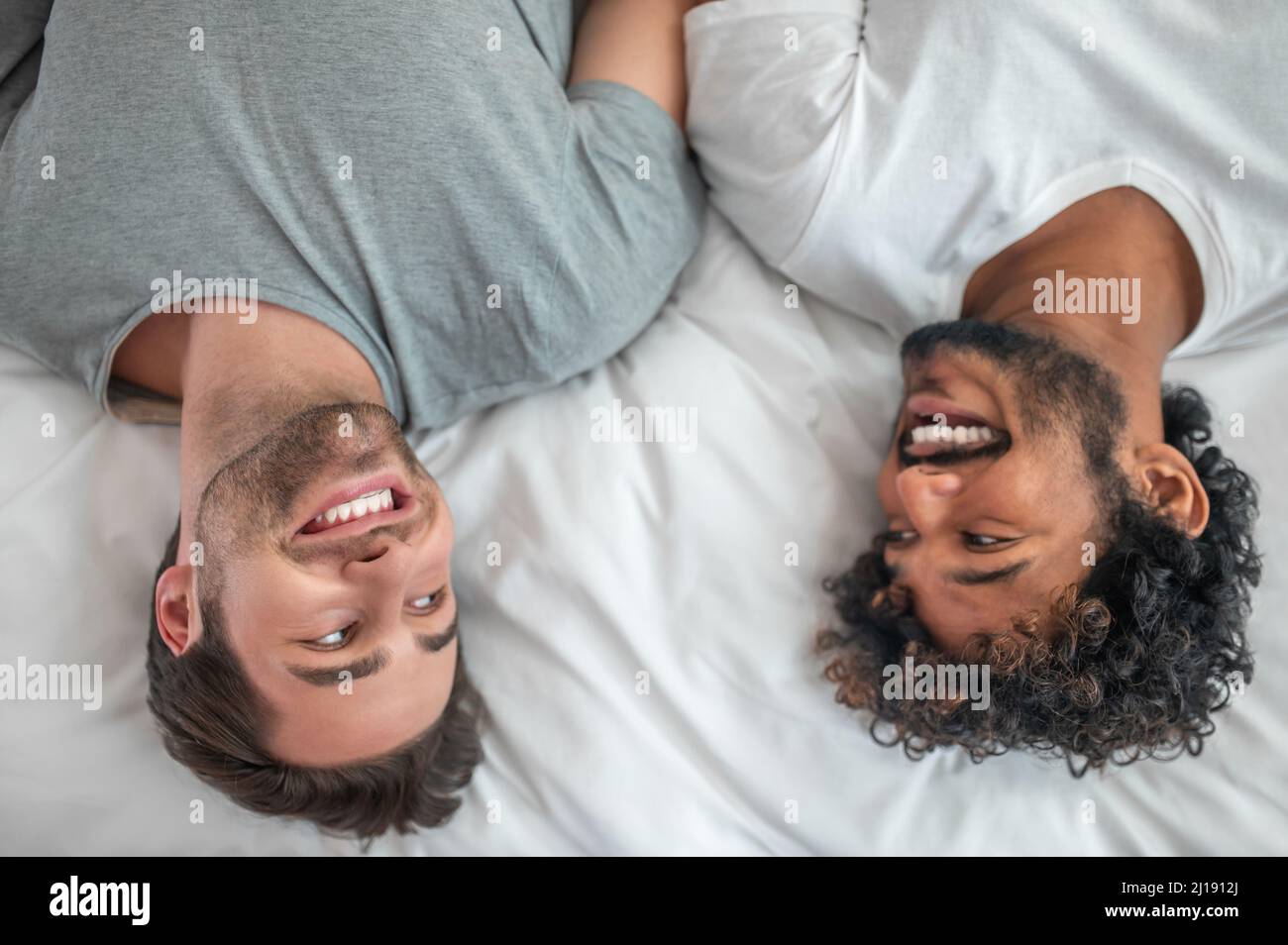 Happy gay couple lying in the bedroom Stock Photo