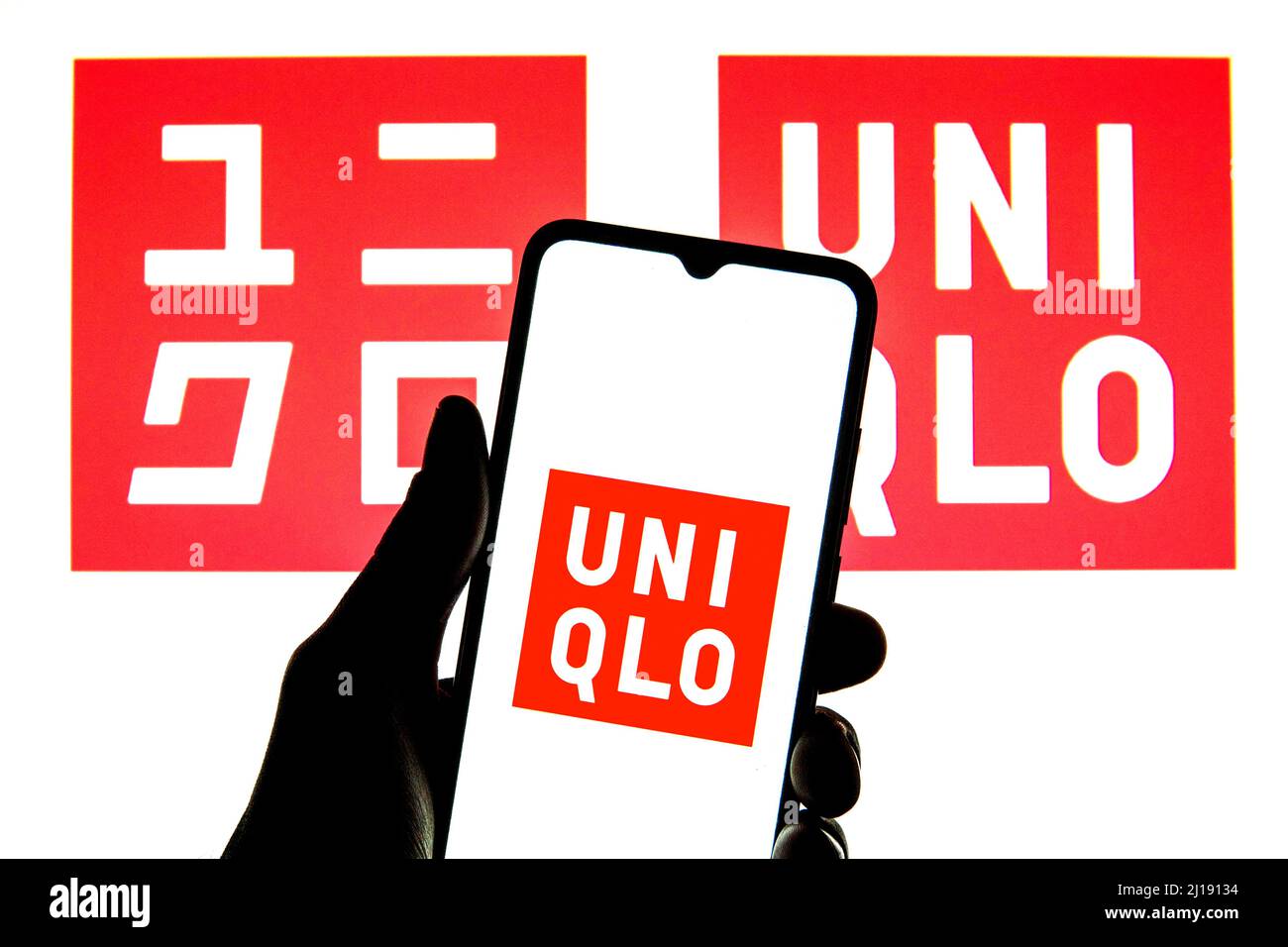 Spain. 23rd Mar, 2022. In this photo illustration a Uniqlo logo seen displayed on a smartphone with a Uniqlo logo in the background. (Credit Image: © Thiago Prudencio/SOPA Images via ZUMA Press Wire) Stock Photo