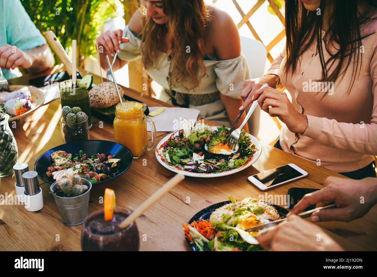 Young friends having fun eating brunch at healthy food restaurant
