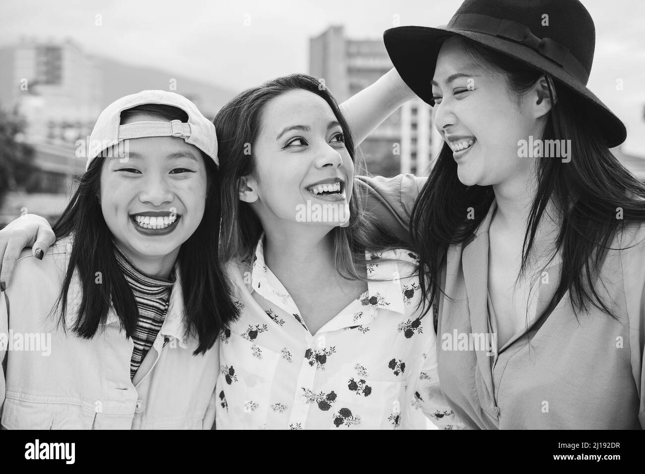 Asian friends having fun together outdoor - Main focus on center girl face - Black and white edition Stock Photo