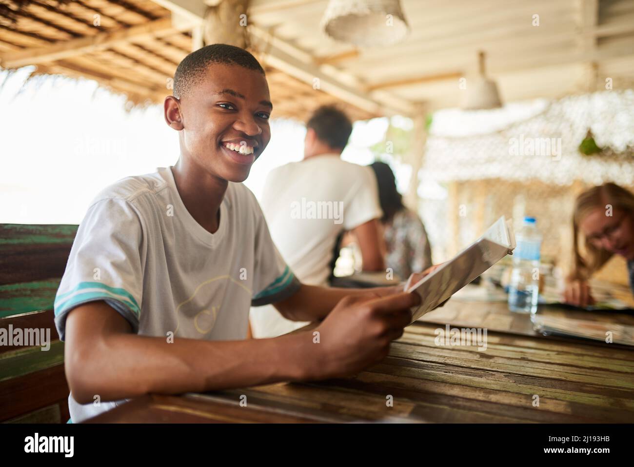 Whats on the menu. Portrait of a young man reading a menu in a restaurant. Stock Photo