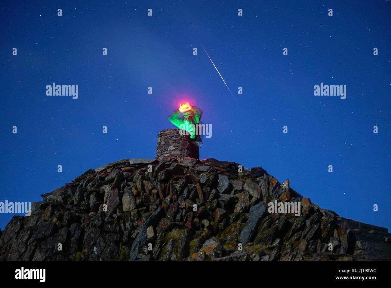 Spectator scanning horizon at Snowdon Summit Cairn Stock Photo