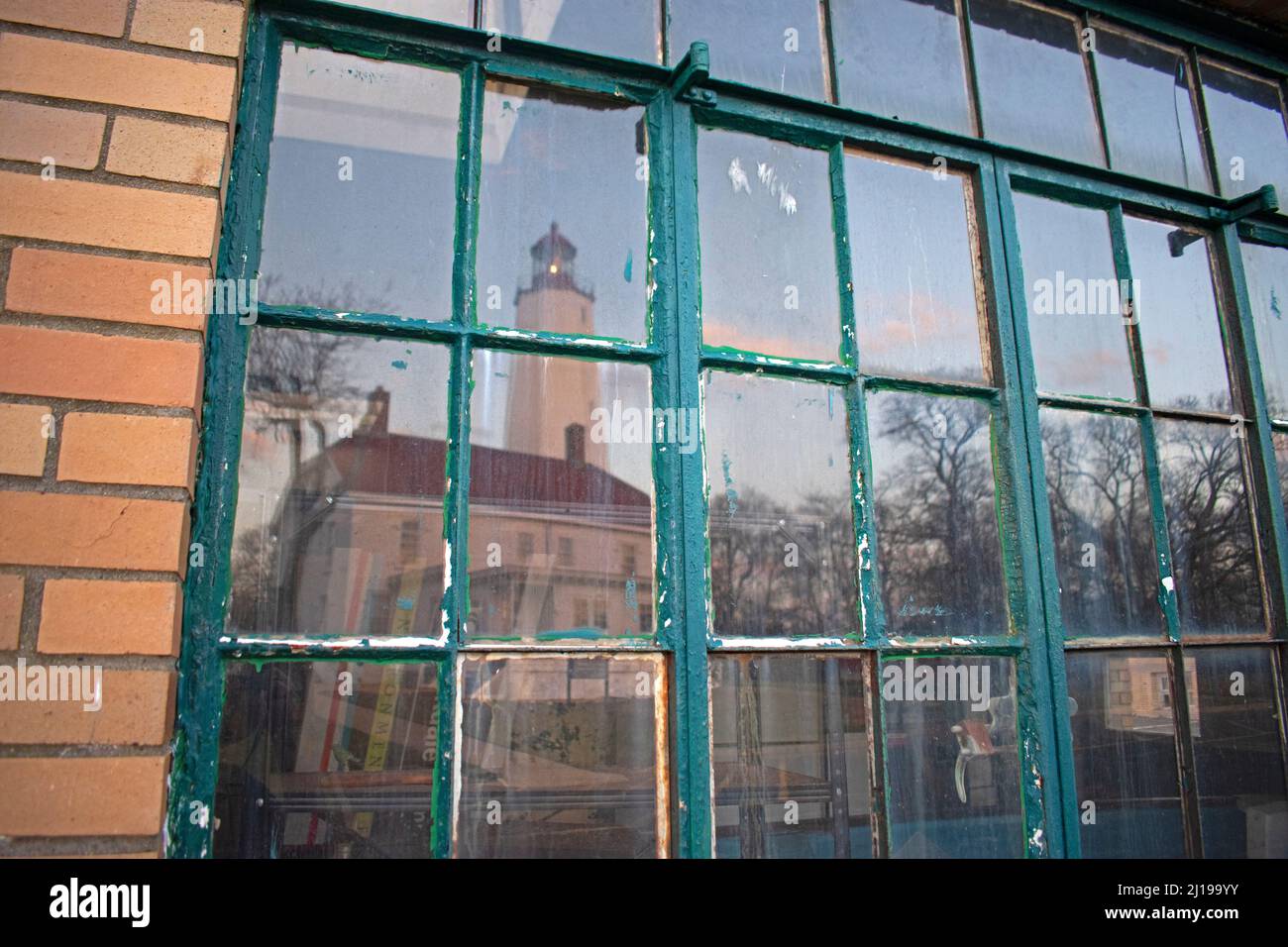 Sandy Hook Lighthouse reflected on the window pane of a nearby building -65 Stock Photo