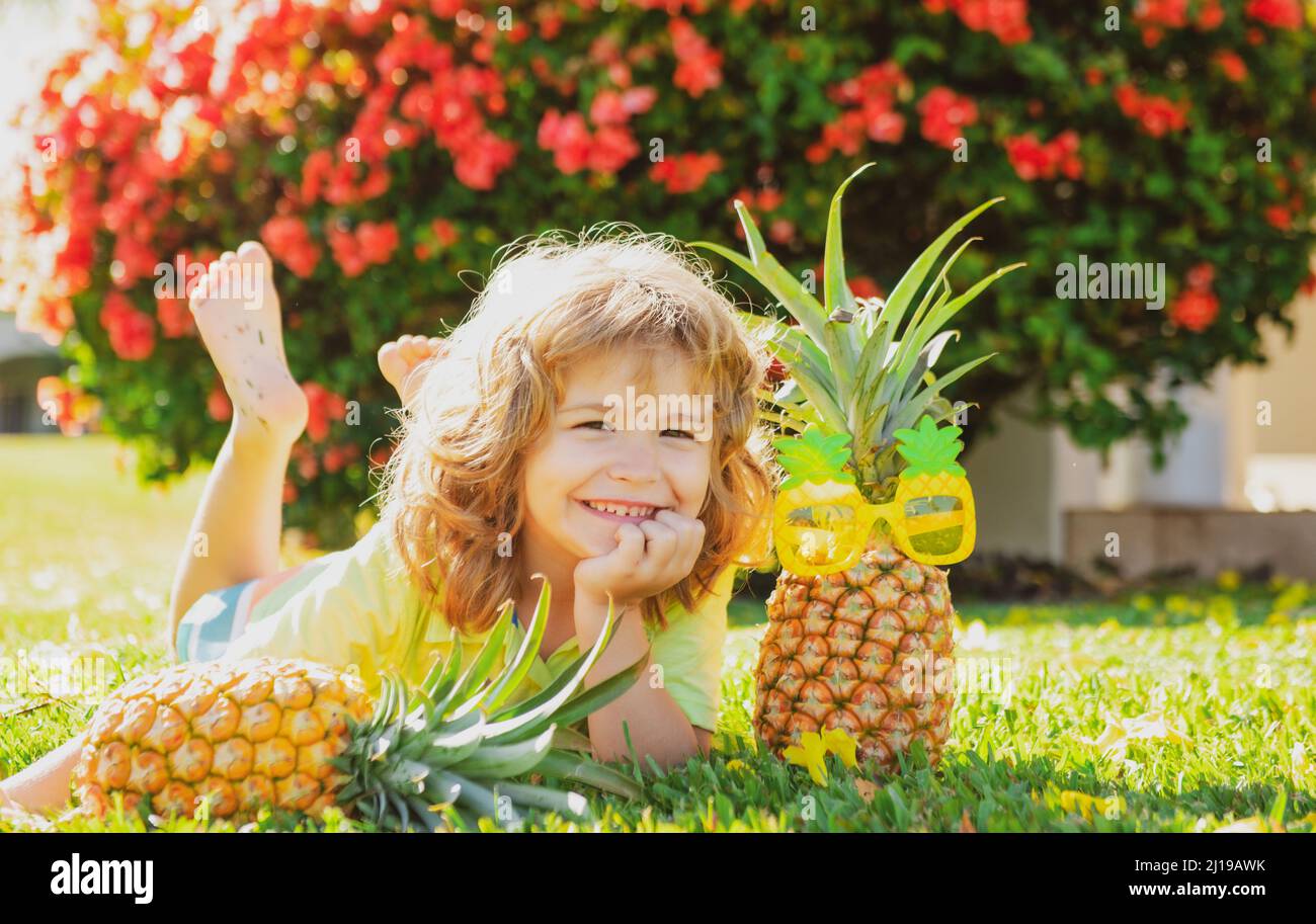 Cute kid with pineapple. Fresh tropical fruits for kids. Healthy