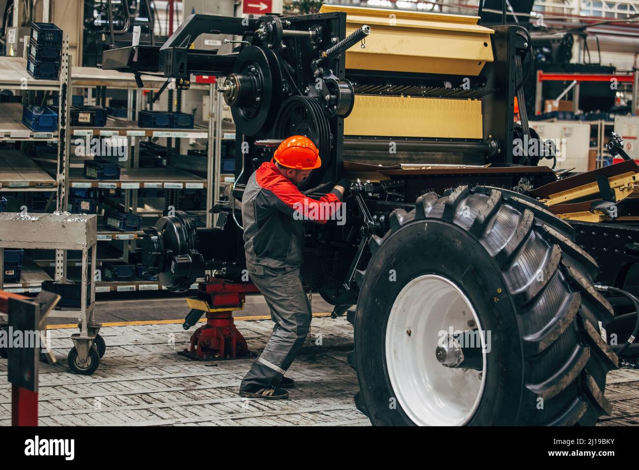 Industrial workers assembles agricultural harvester in workshop. Stock Photo
