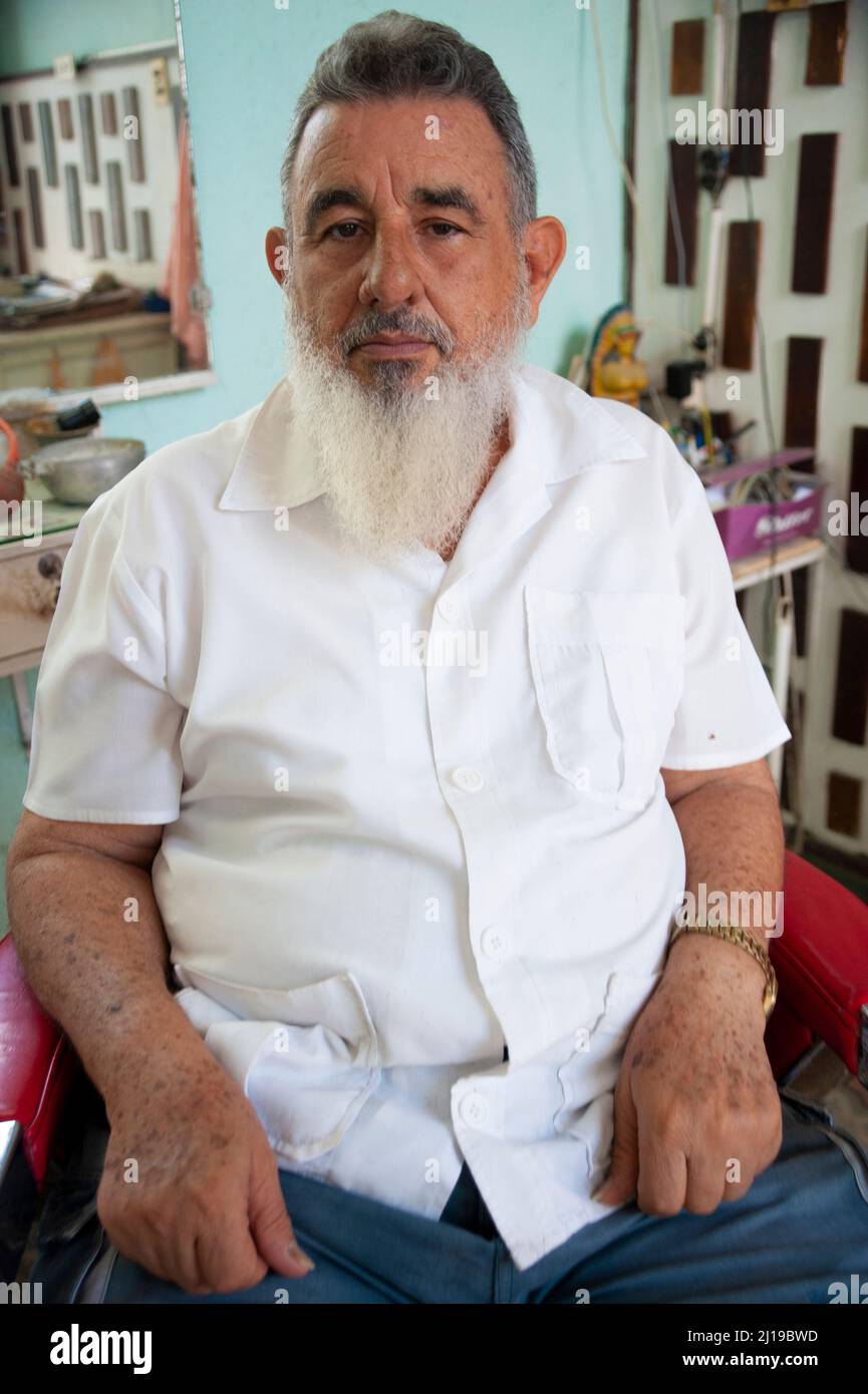 A barber in the town of Ciego de Avila, Cuba looks to be the fitting image of former Cuban president Fidel Castro. Stock Photo
