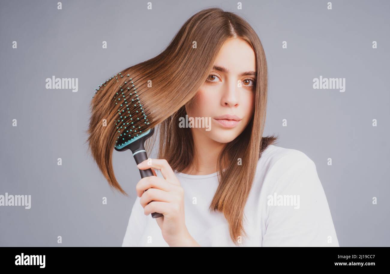 Woman brushing straight natural hair with comb. Girl combing hair with