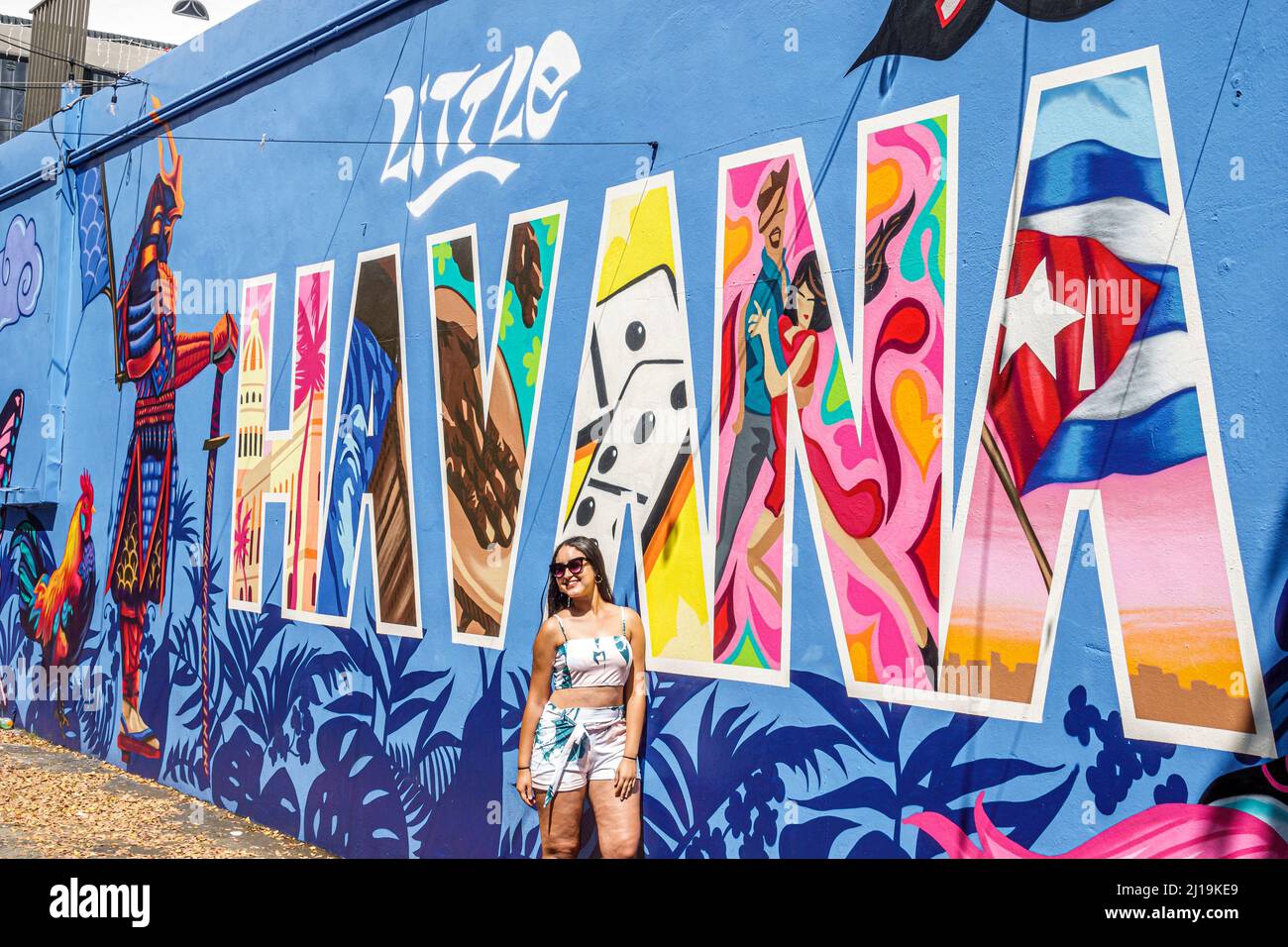 Little Havana Miami Florida Calle Ocho 8 8th Street Hispanic Cuban neighborhood historic district wall art artwork teen girl posing Stock Photo