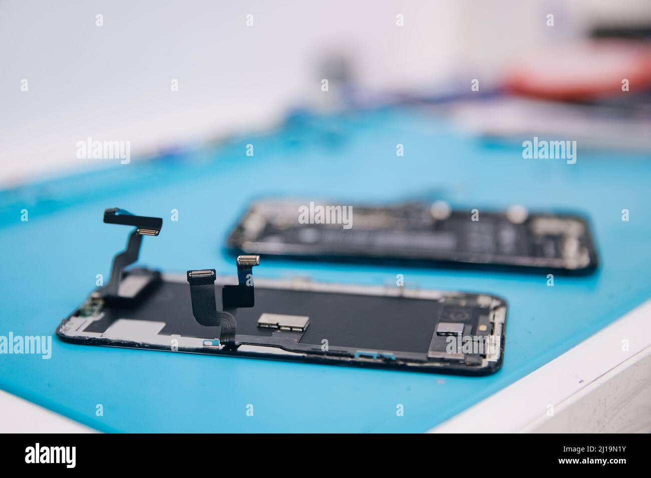Concept repair modern mobile phone, master disassembles case to replace broken screen or replacement battery degradation. Stock Photo