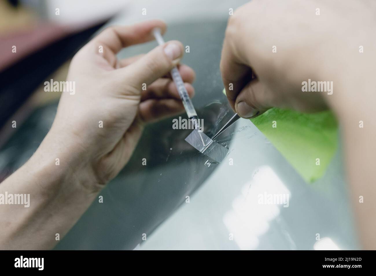 Worker fixes crack in car glass windshield, repair drills and pours epoxy Stock Photo Alamy