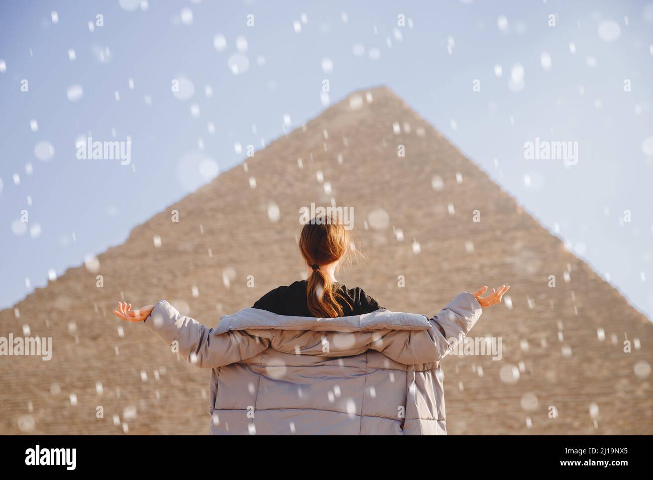 Winter snow on background of Pyramids of Cheops Egypt tourist girl in