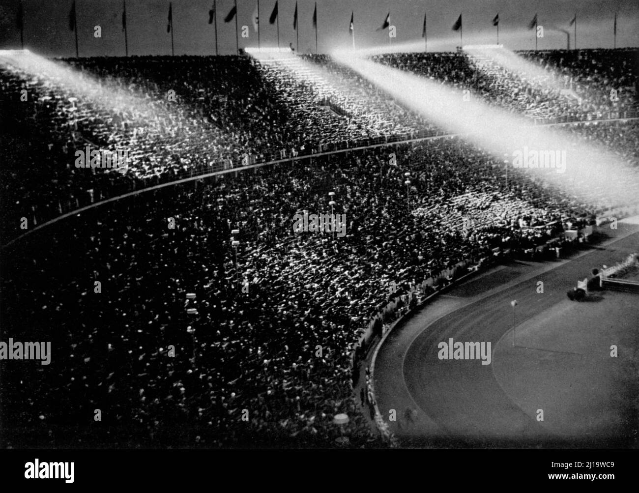 The spotlights chase beams of light over the crowds, fanfares cut the ribbons of the night like swords. . text of the coverage of the closing ceremony Stock Photo