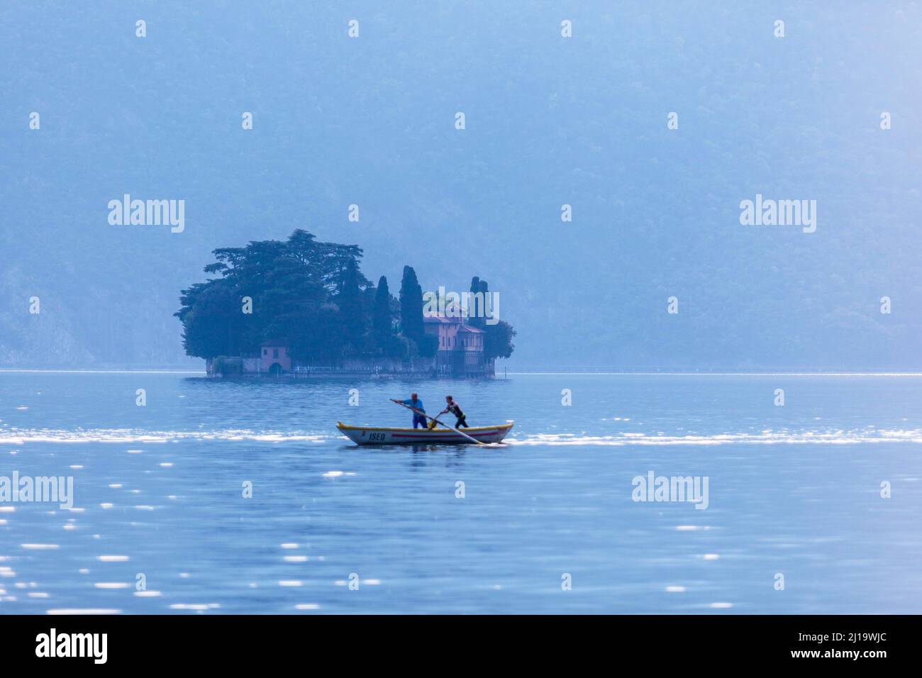 Two men rowing a Naet the traditional boat of the region near Monte Isola, Iseo Lake, Lombardy, Italy Stock Photo