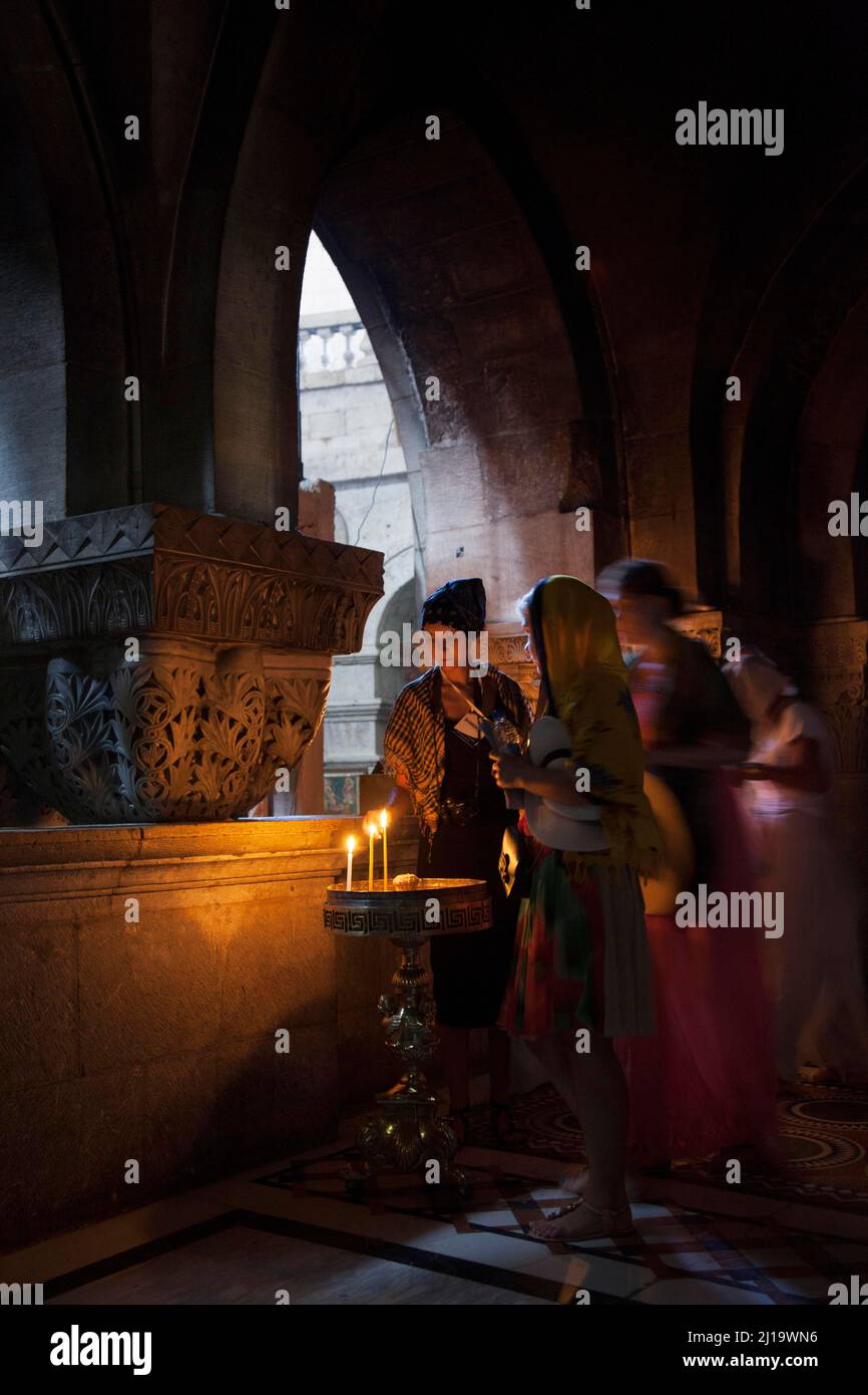 Believers lighting a candle at the Greek Orthodox Chapel inside the Crusader Church within the walls of ancient Jerusalem, Isreal, Middle East, Asia Stock Photo