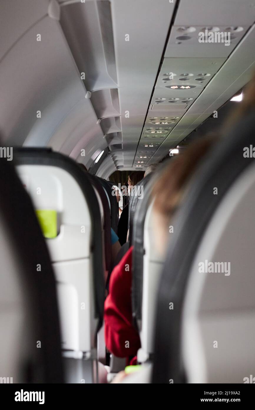 A view inside the plane between rows of seats. The concept of rest and travel. Vertical photo. Stock Photo