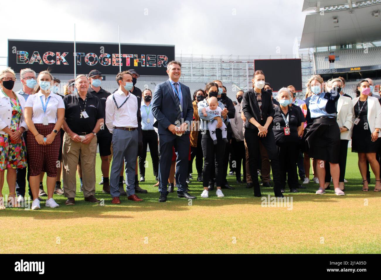 Auckland, New Zealand. 24 March 2022: New Zealand Prime Minister Jacinda  Ardern visits the Eden Park stadium sporting facility and poses with staff  (including one holding a baby) the day after announcing