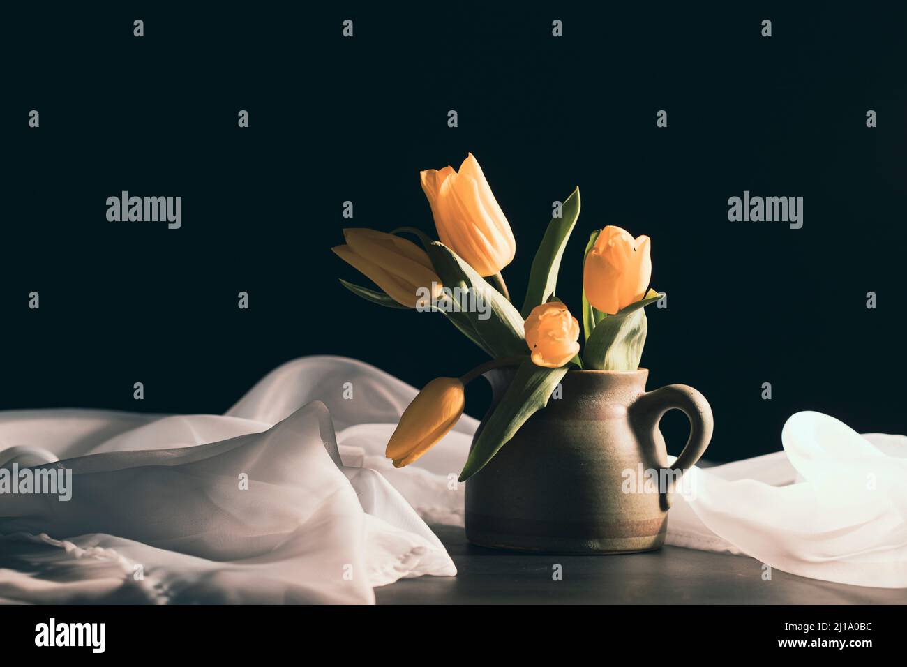 Still life with bouquet of yellow tulip flowers in old vintage jug, in ...