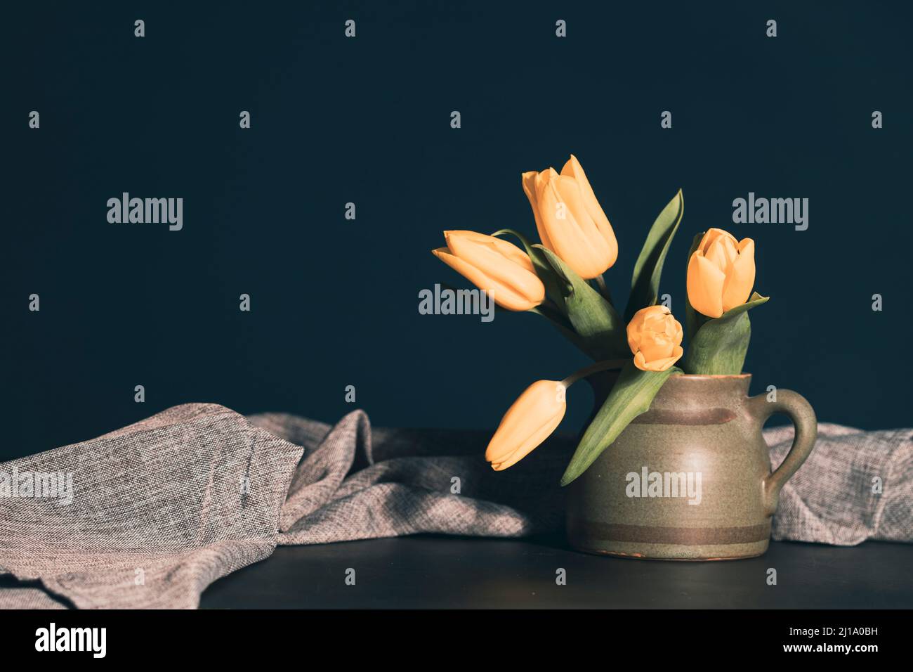Still life with bouquet of yellow tulip flowers in old vintage jug, in ...