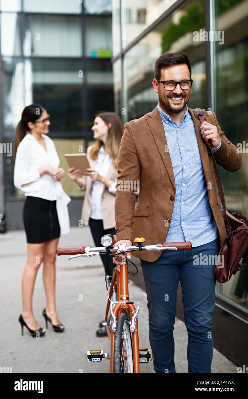 Portrait of happy fit business man with bicycle in modern city outdoors. Stock Photo