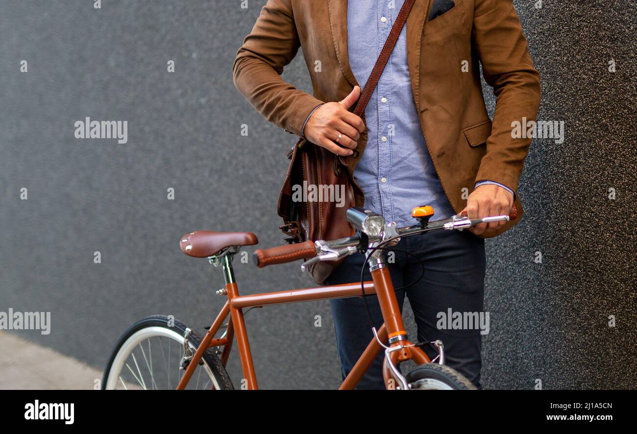 Portrait of happy fit business man with bicycle in modern city outdoors. Stock Photo