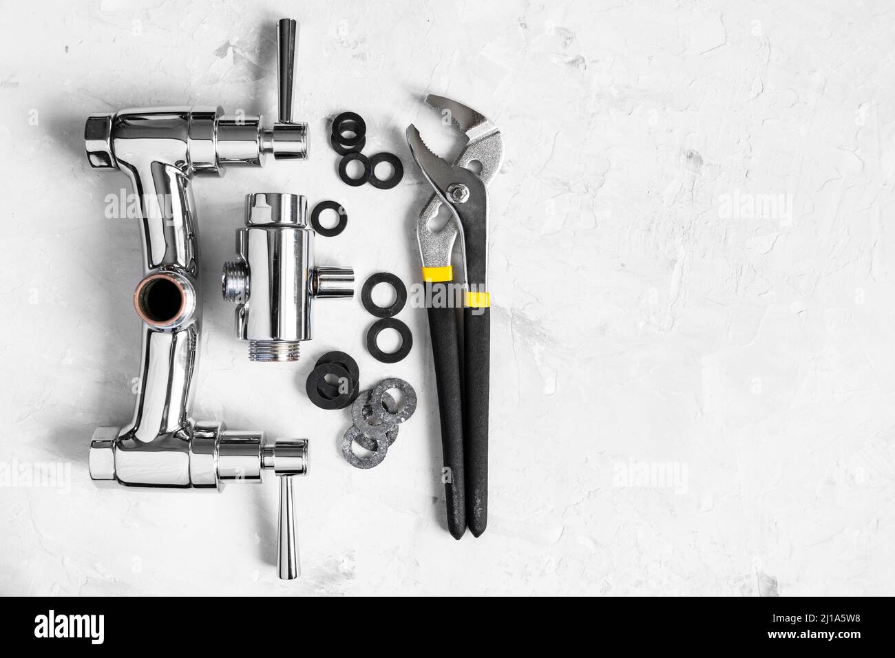 plumbing background top view of wrench, gaskets, disassembled shower faucet valve, diverter on