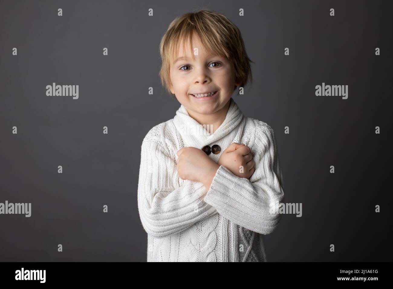 Cute little toddler boy, showing I LOVE YOU gesture in sign language on