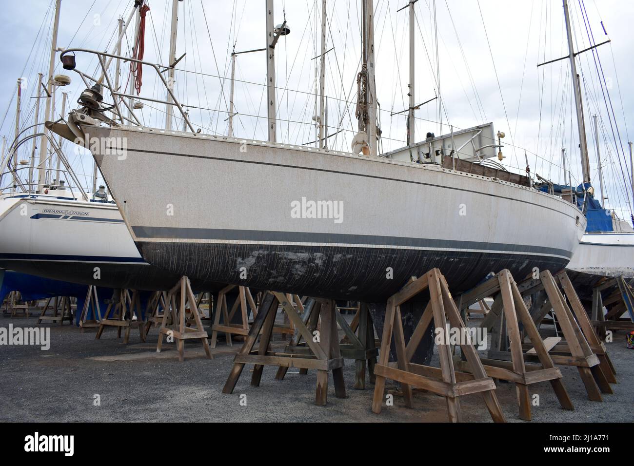 Dirty sailing yacht stored in Almerimar marina boatyard, Almerimar, Spain Stock Photo